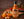 Sesame Buffalo Signature Sauce bottle with sauce in bowl, fresh ginger, and oranges on wooden table, gluten-free and vegan.